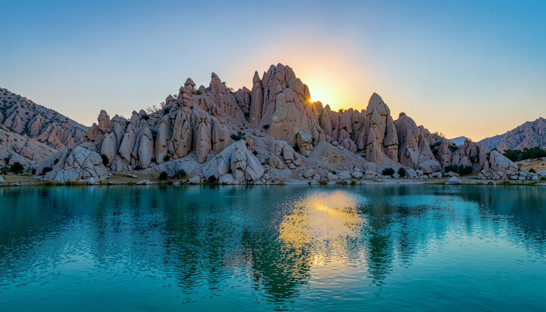 Matahari terbit di atas Pyramid Lake, formasi batuan tufa menjulang dari air tenang berwarna biru kehijauan